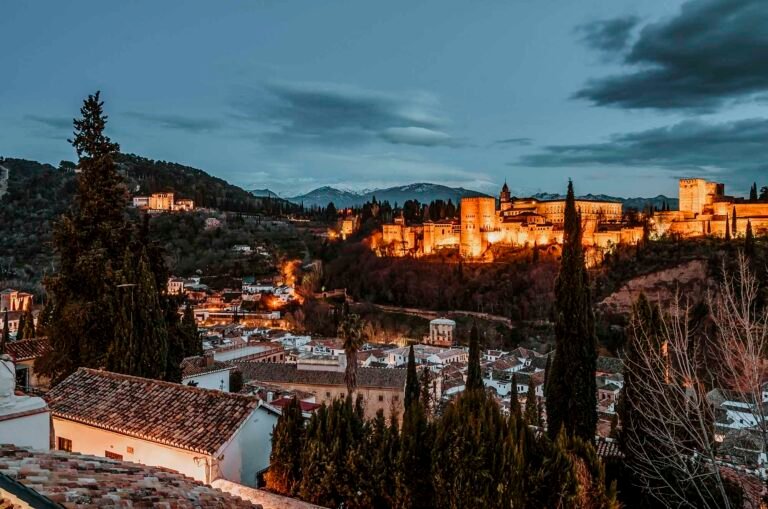 Illuminated Alhambra Palace at dusk overlooking Granada, inspiring alhambra palace night tour attendance revenue growth.