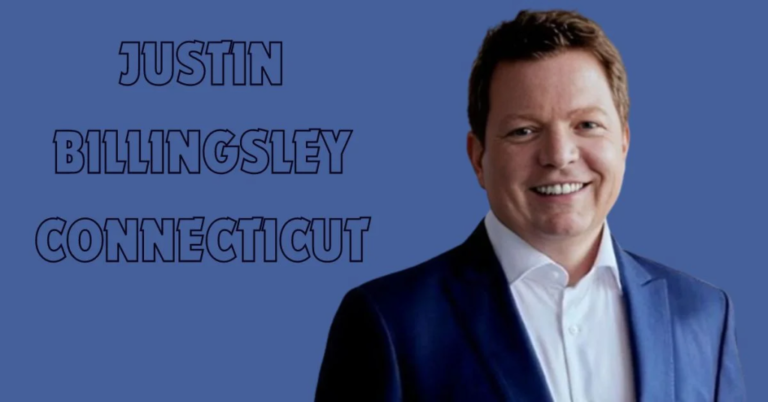 Justin Billingsley Connecticut headshot: Smiling man in suit on blue background