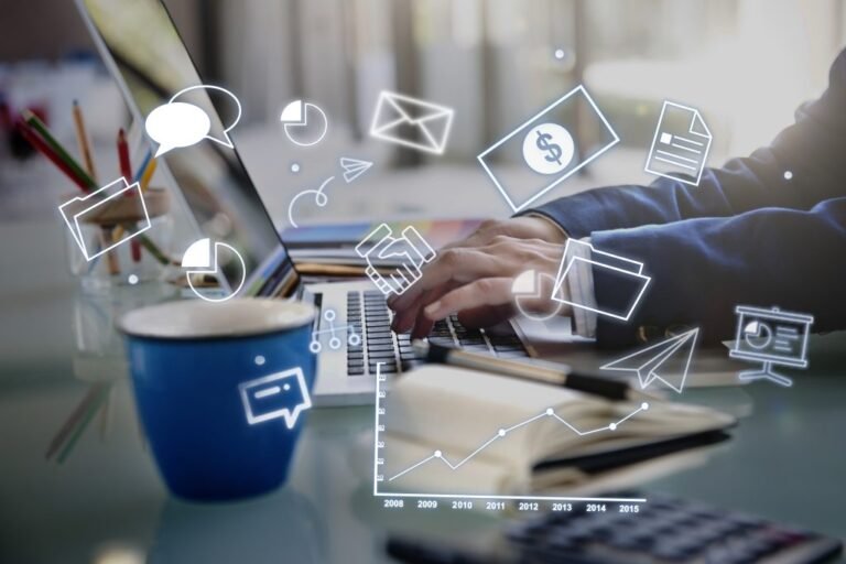 Freelancer working on laptop with business icons like graphs and dollars.